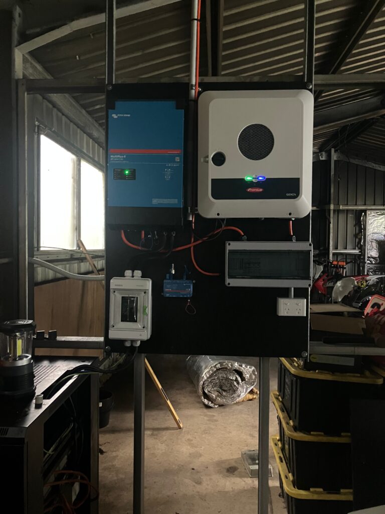Victron and Fronius solar equipment mounted inside a shed