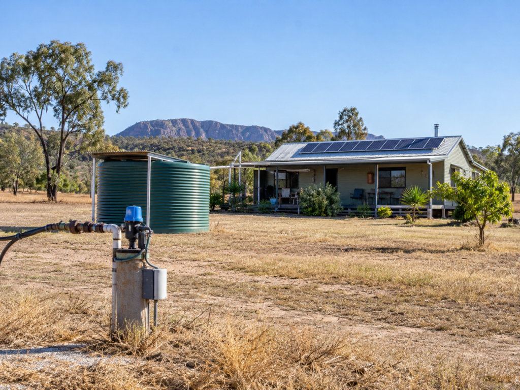 Rural home with rooftop solar panels, a bore pump and water storage tank